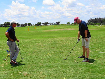 Glen Beaver observes golf student apply swing technique for one-handed golfer.
