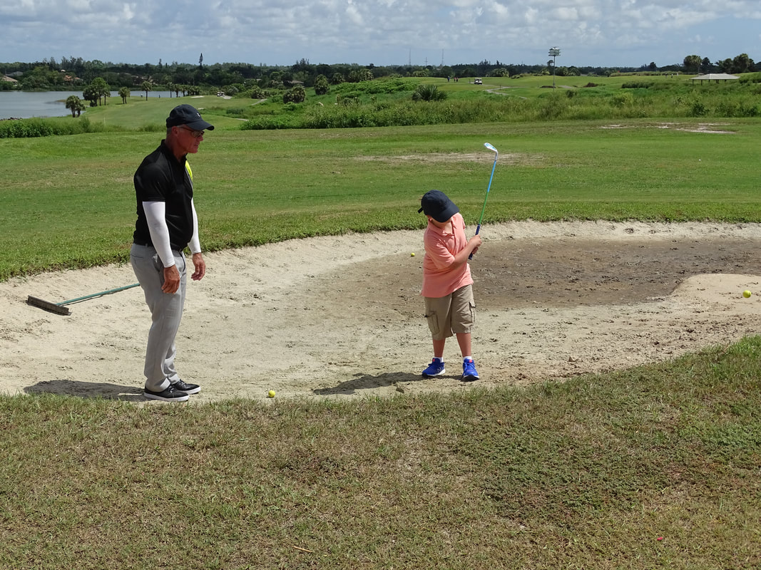 Glen Beaver encouraging junior golf student at Park Ridge Golf Course